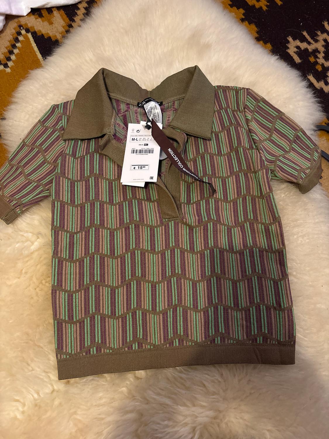 Green and brown striped polo shirt with a price tag of €15. White and brown carpet background with a geometric pattern.