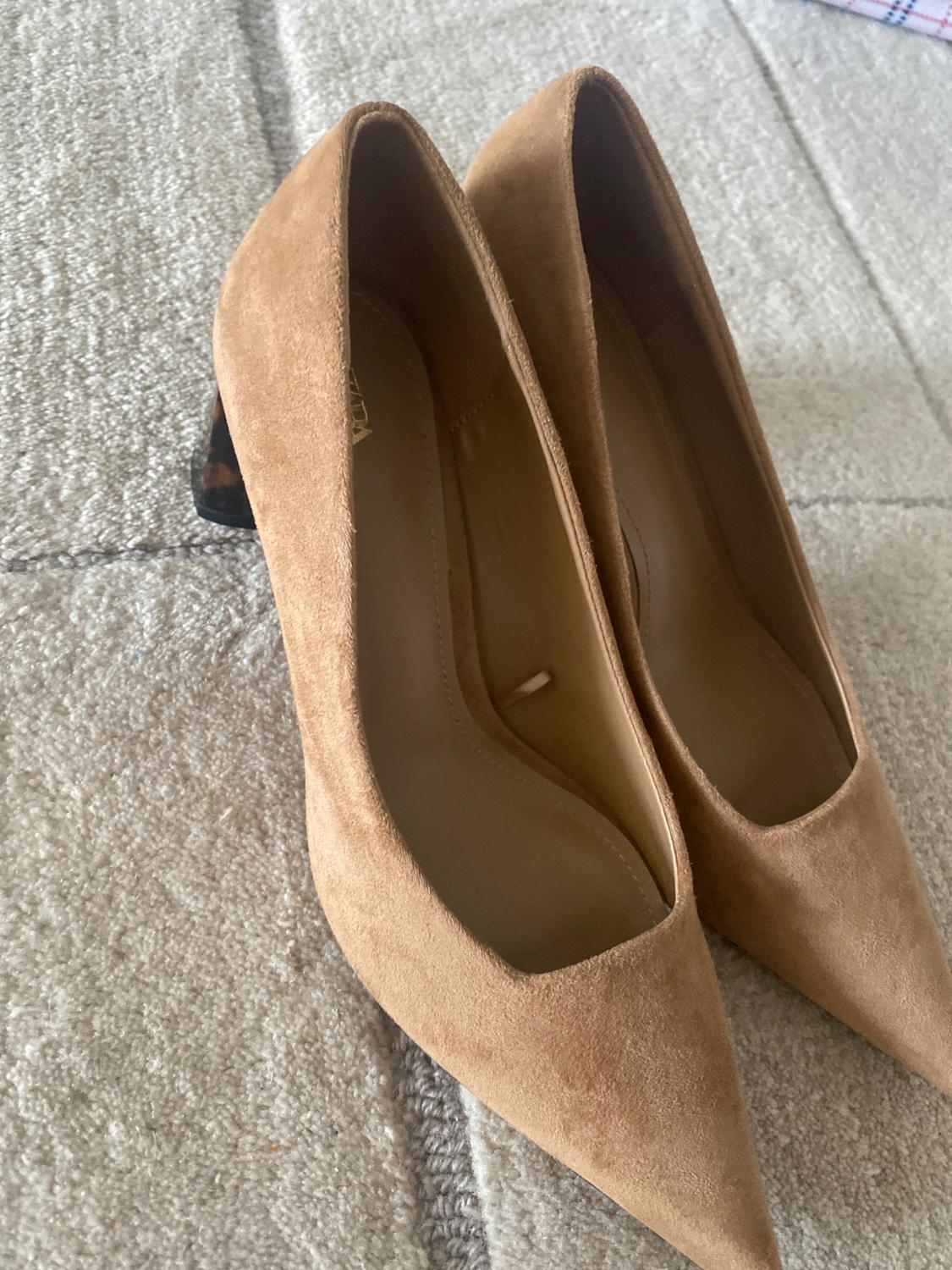 Detail of camel high-heeled shoes with a pointed toe and a medium heel.