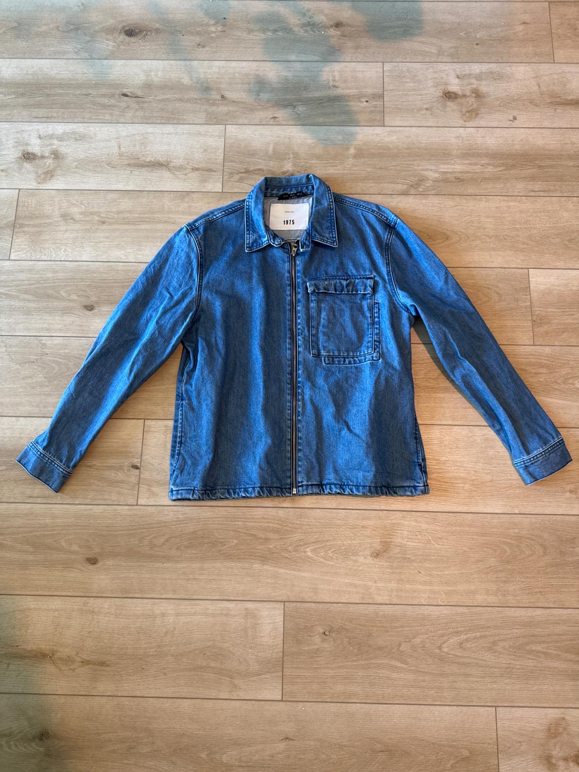 Front view of a blue jacket with a zipper and a left front pocket.