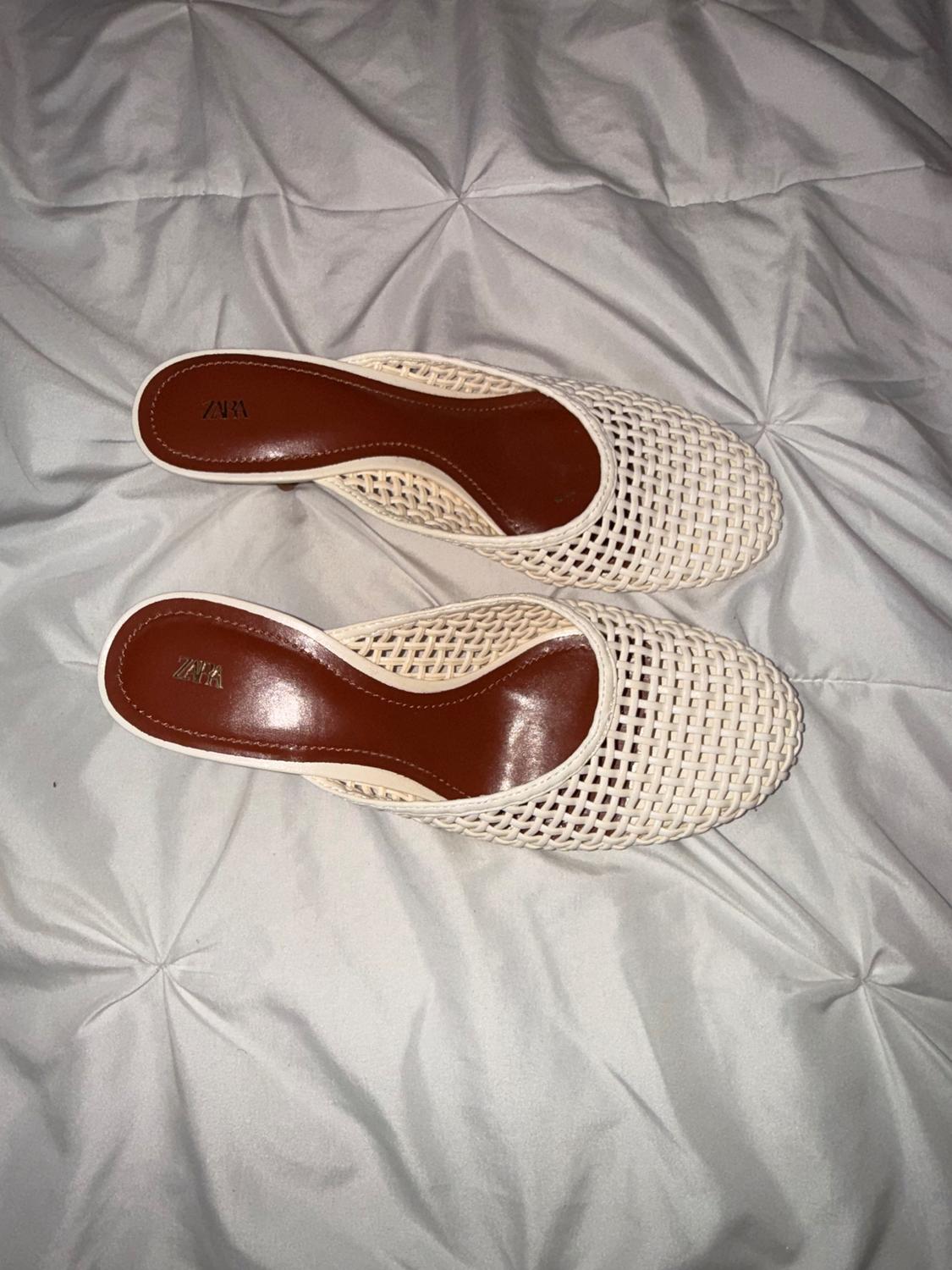 Beige mesh shoes with a brown insole on a white bedspread. The "ZARA" brand is visible on the insole.