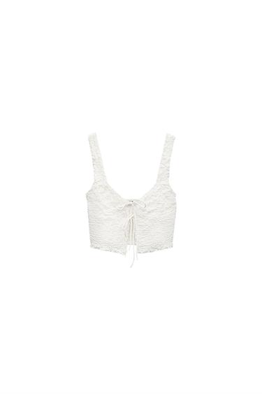 Front view of a white top with straps and front tie.