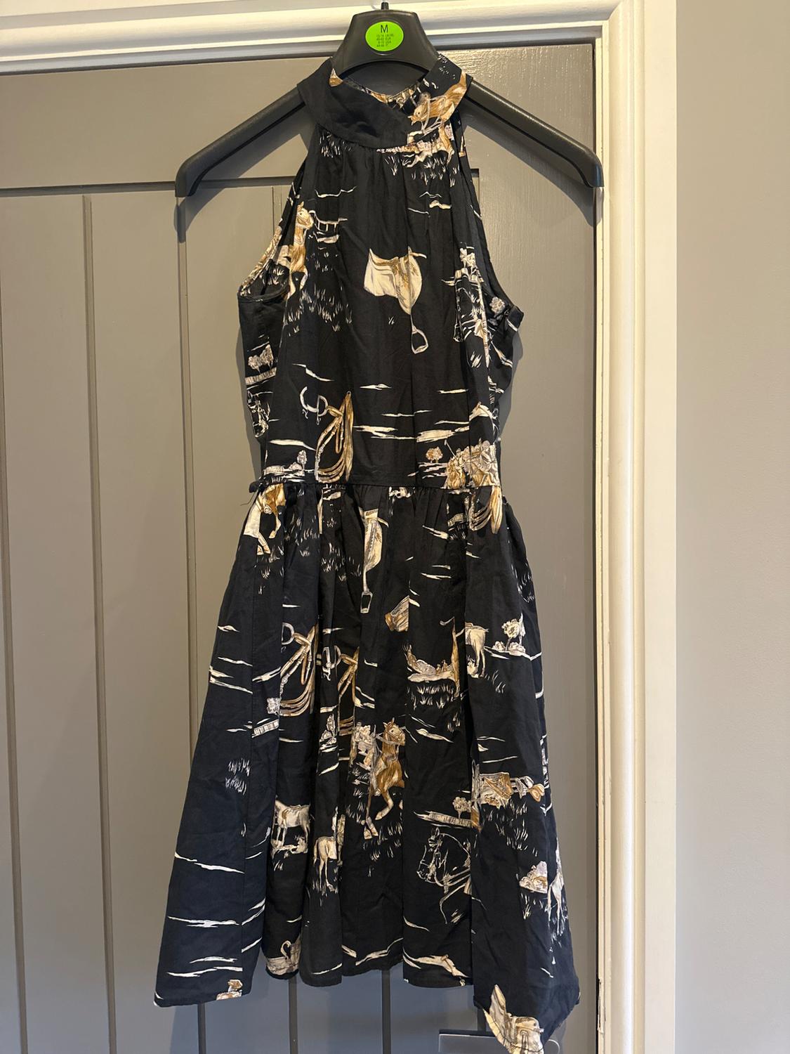Front view of a black dress with an animal print and a high neck.