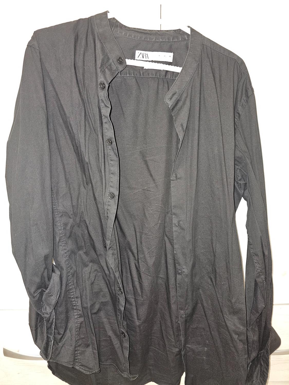 Black long-sleeved shirt with a grandad collar and front buttons. Visible label with text "ZARA". White background.