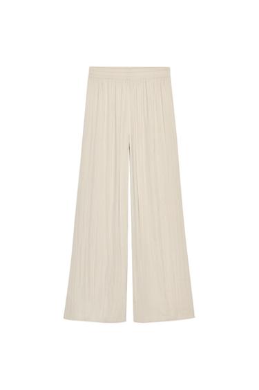 Front view of wide-leg beige trousers with elasticated waistband