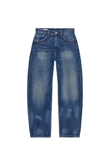 Front view of blue jeans with a distressed effect, five pockets, and button and zip fastening.
