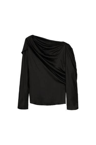 Black long-sleeve top with an asymmetric neckline and draped detail, on a white background.