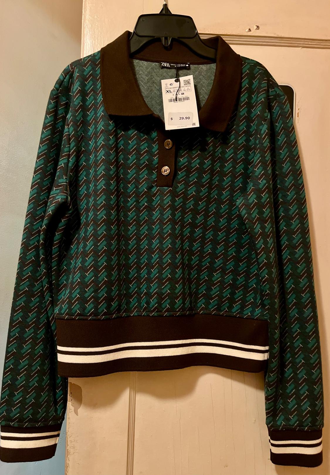 Polo with lapel collar and long sleeves. Rib trim. Front button closure.