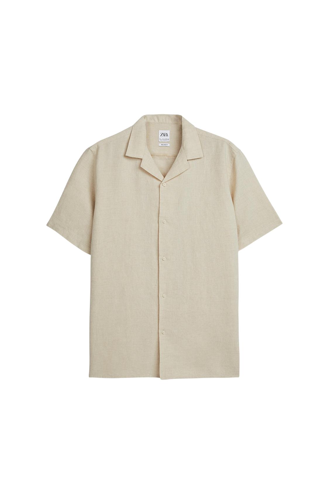 Beige short-sleeved shirt with a lapel collar, buttoned against a white background. The inner label reads ZARA.
