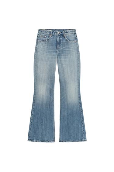 Front view of low-rise blue jeans with a flared cut, five pockets, and a zip and button fastening.