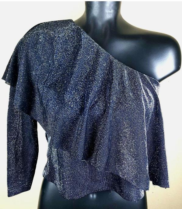 Close-up of a black asymmetrical glitter top with one bare shoulder.