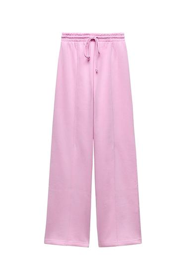 Pants with a high waist with adjustable elastic drawstring waistband. Straight leg and pronounced seams.