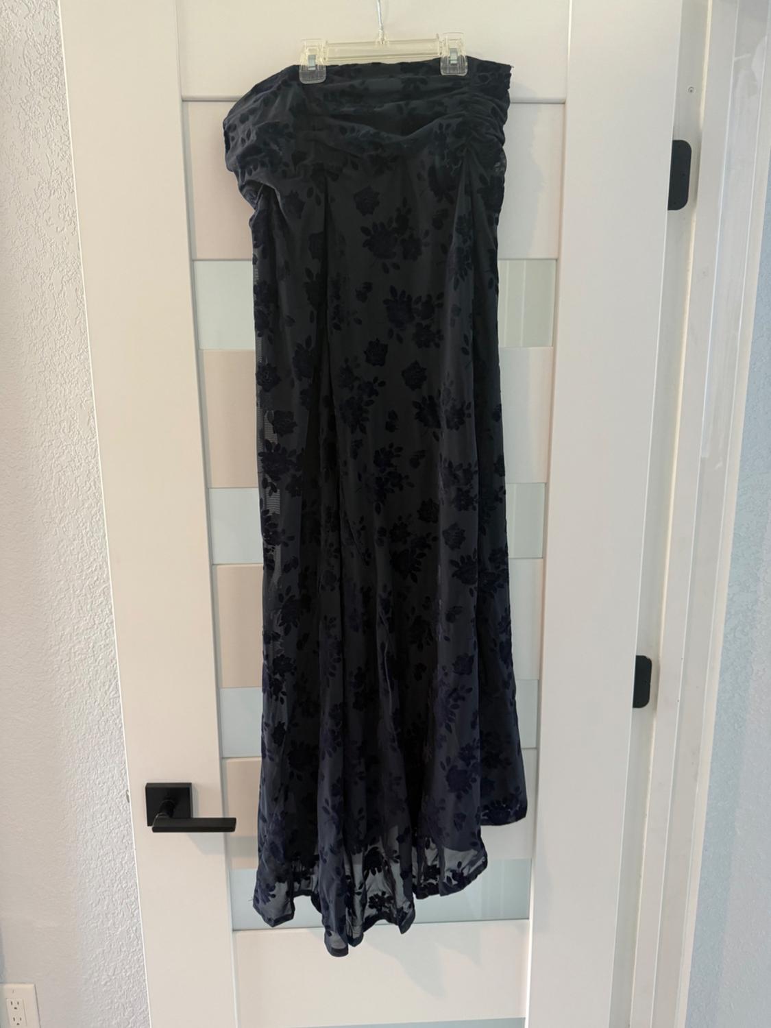 Front view of a black dress with a dark floral print and a draped bust design.