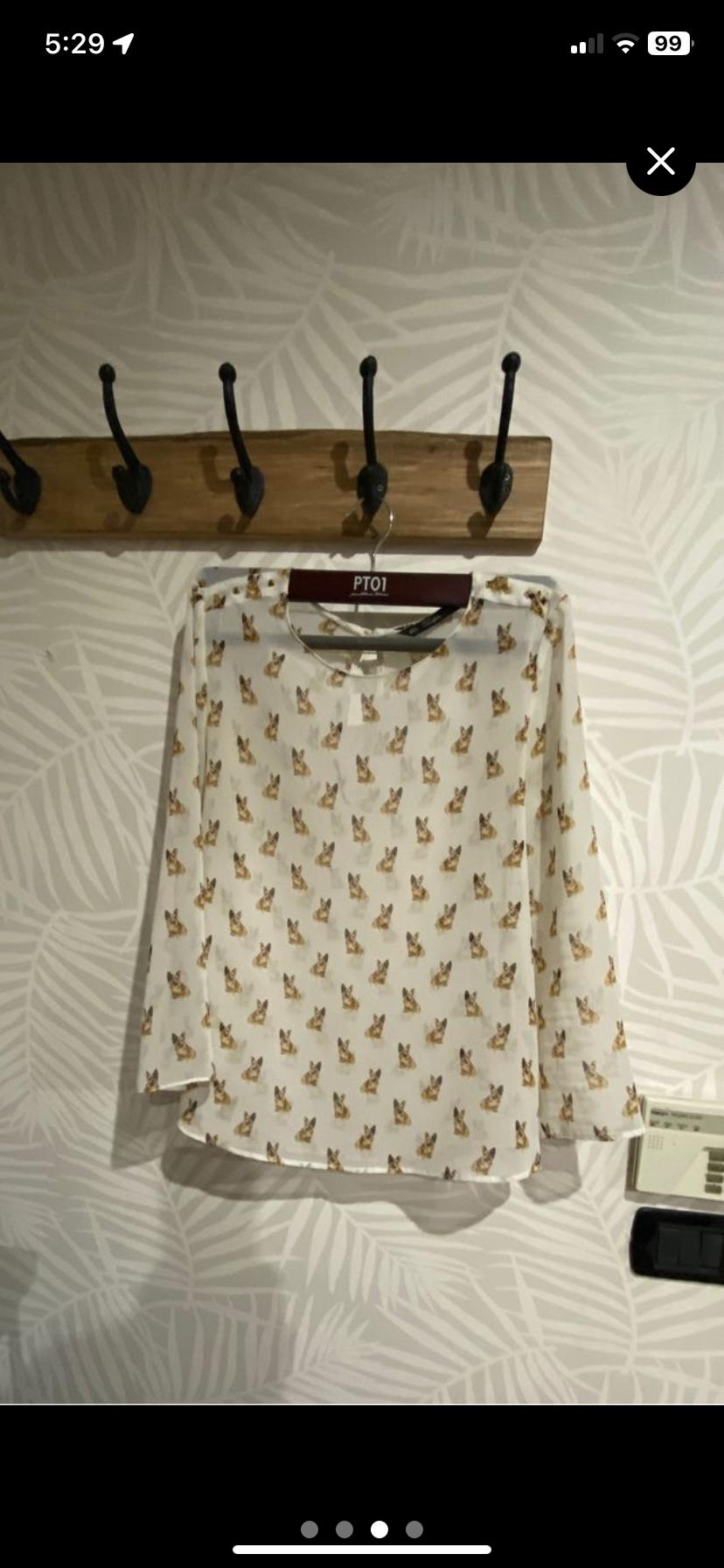 Front view of a white blouse with a small dog print.