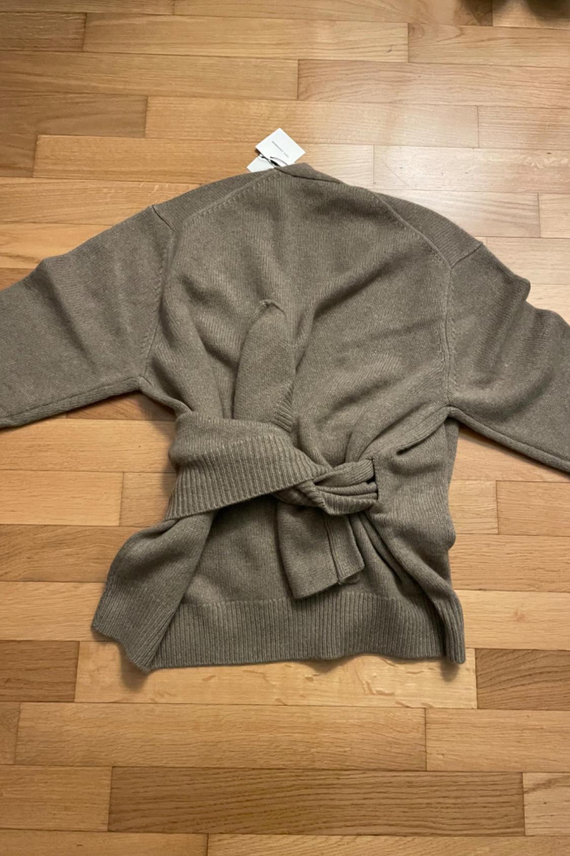 Rear view of brown jacket with tied belt and long sleeves.
