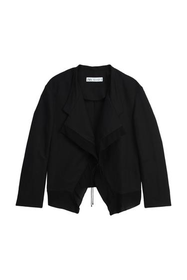 Front view of a black jacket with lapels and adjustable fastening.
