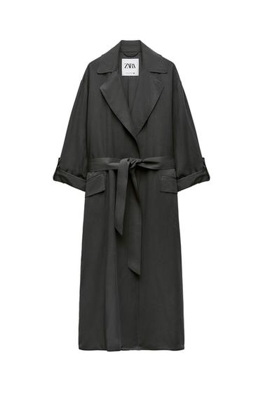 Long black coat with belt and wide lapels. Visible label with the text "ZARA". Rolled-up sleeves and front pockets.