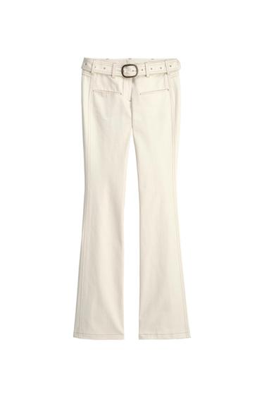Ecru bell-bottom pants with matching belt, round buckle, and front seams on a white background.