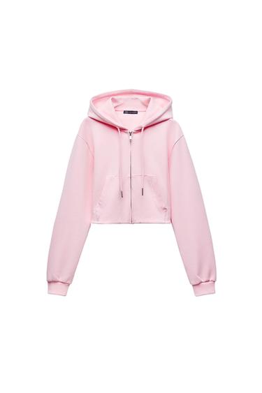 Front view of a pink hoodie with a hood, zip and front pockets.