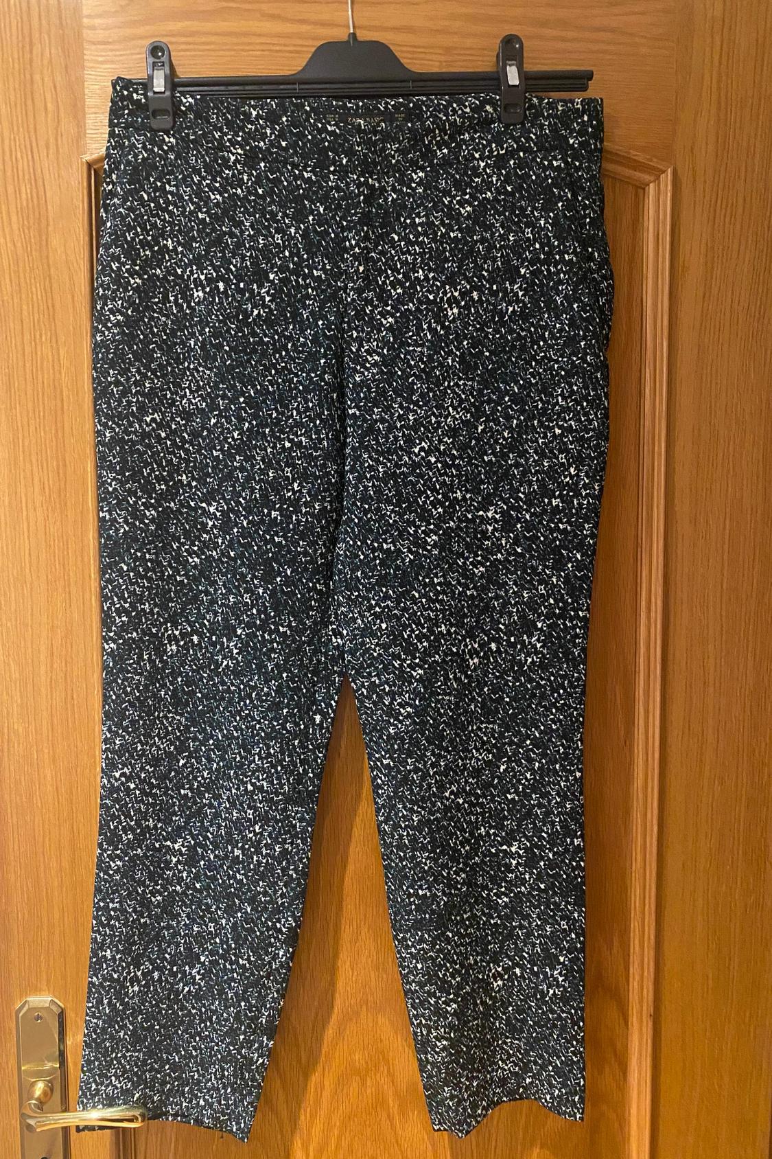 Front view of trousers with black and white speckled print.