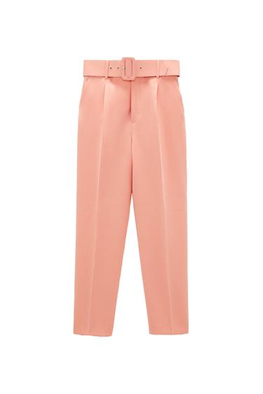 Pink trousers with a matching belt featuring a rectangular buckle and front pleats, against a white background.