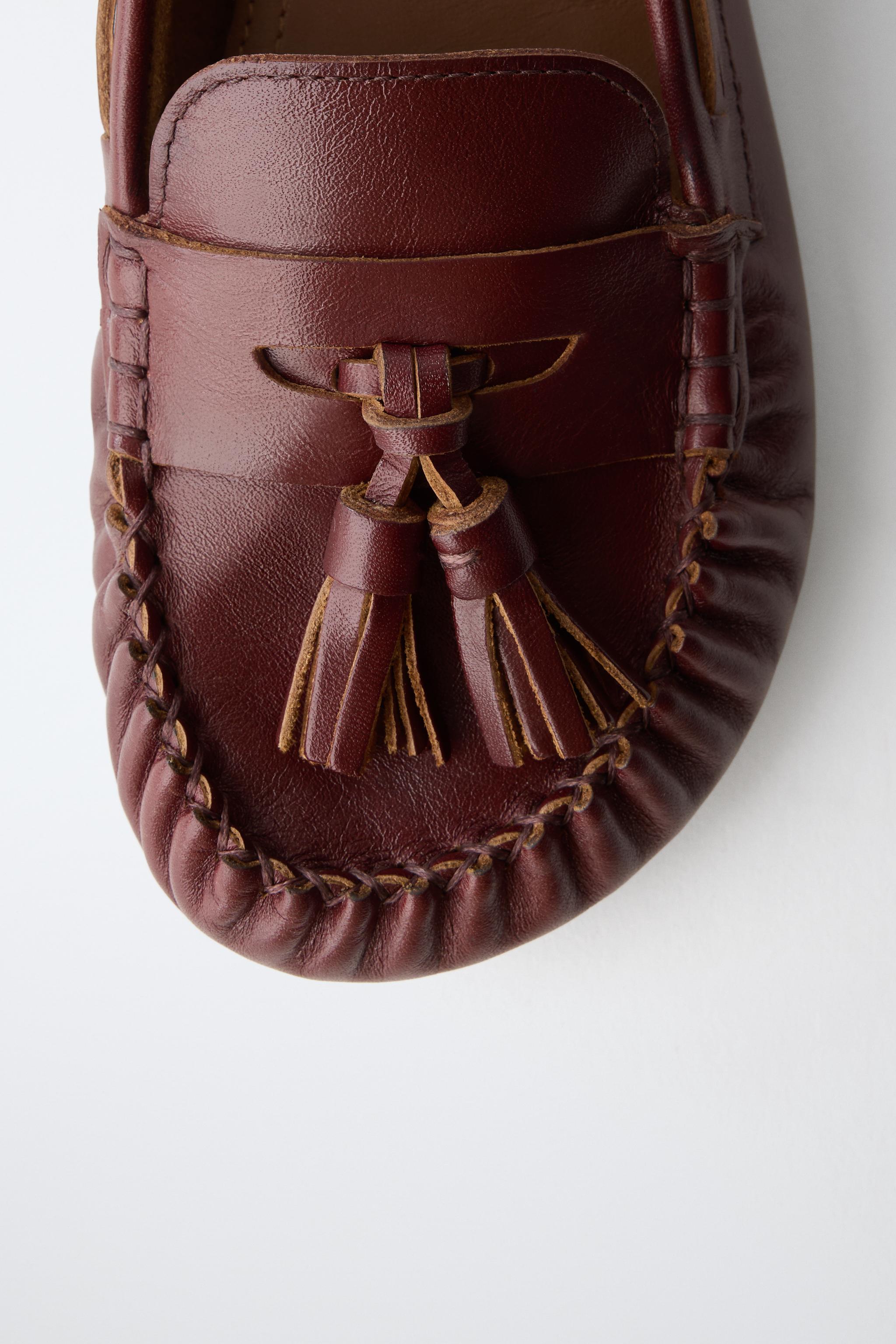 MOCASSINS EN CUIR À POMPONS