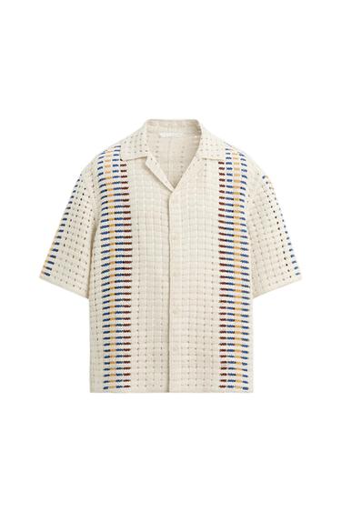 Open-knit cream-colored shirt with vertical stripes in blue, red, and yellow. Short sleeves and a classic collar.