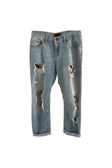 Front view of blue jeans with rips and side pockets.