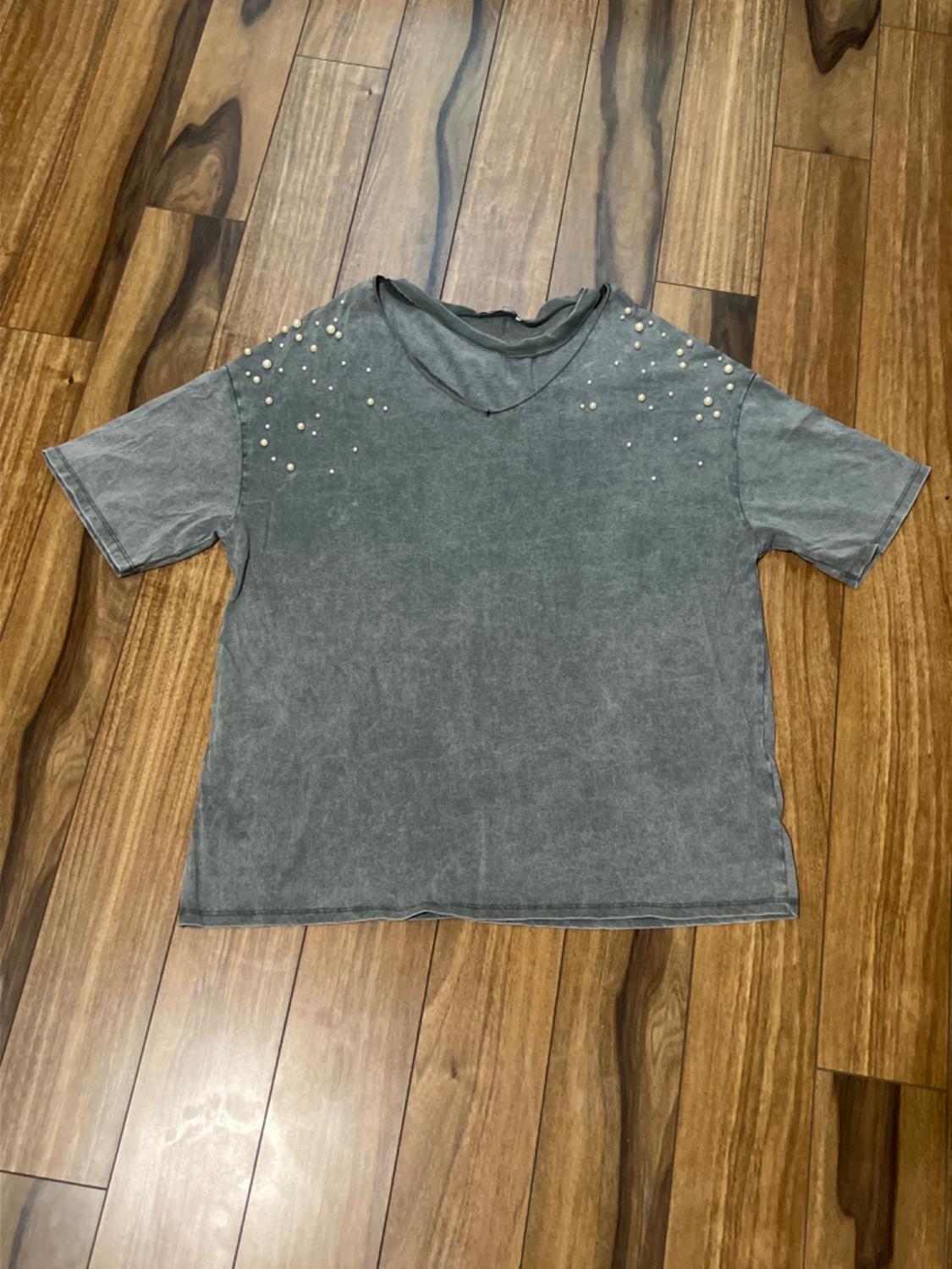 Front view of a grey V-neck t-shirt with pearl details on the shoulders.