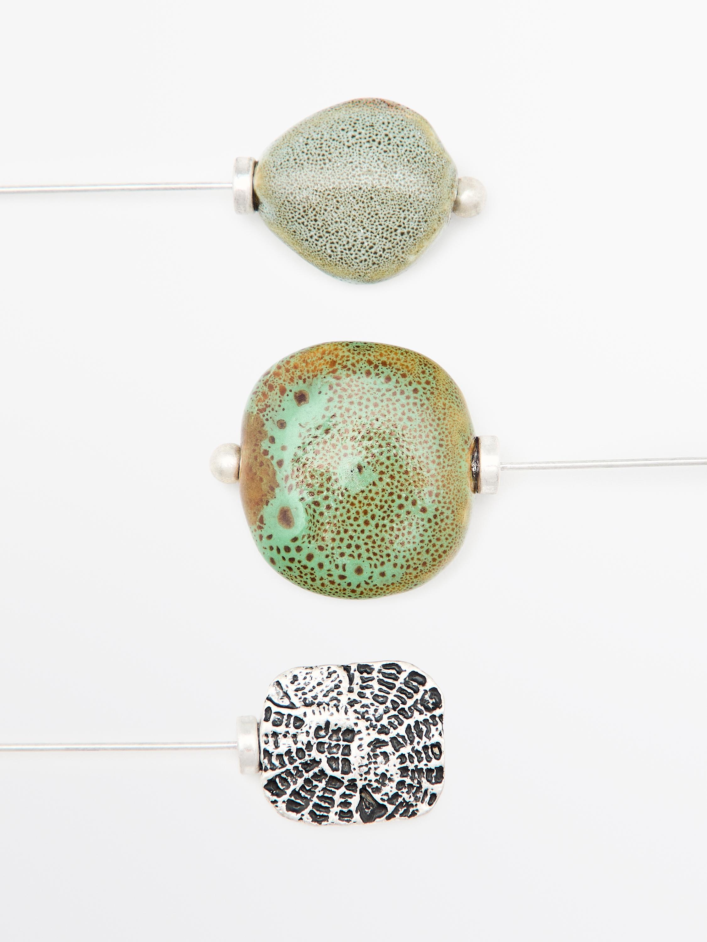 Brooch with textured ceramic piece and medallion