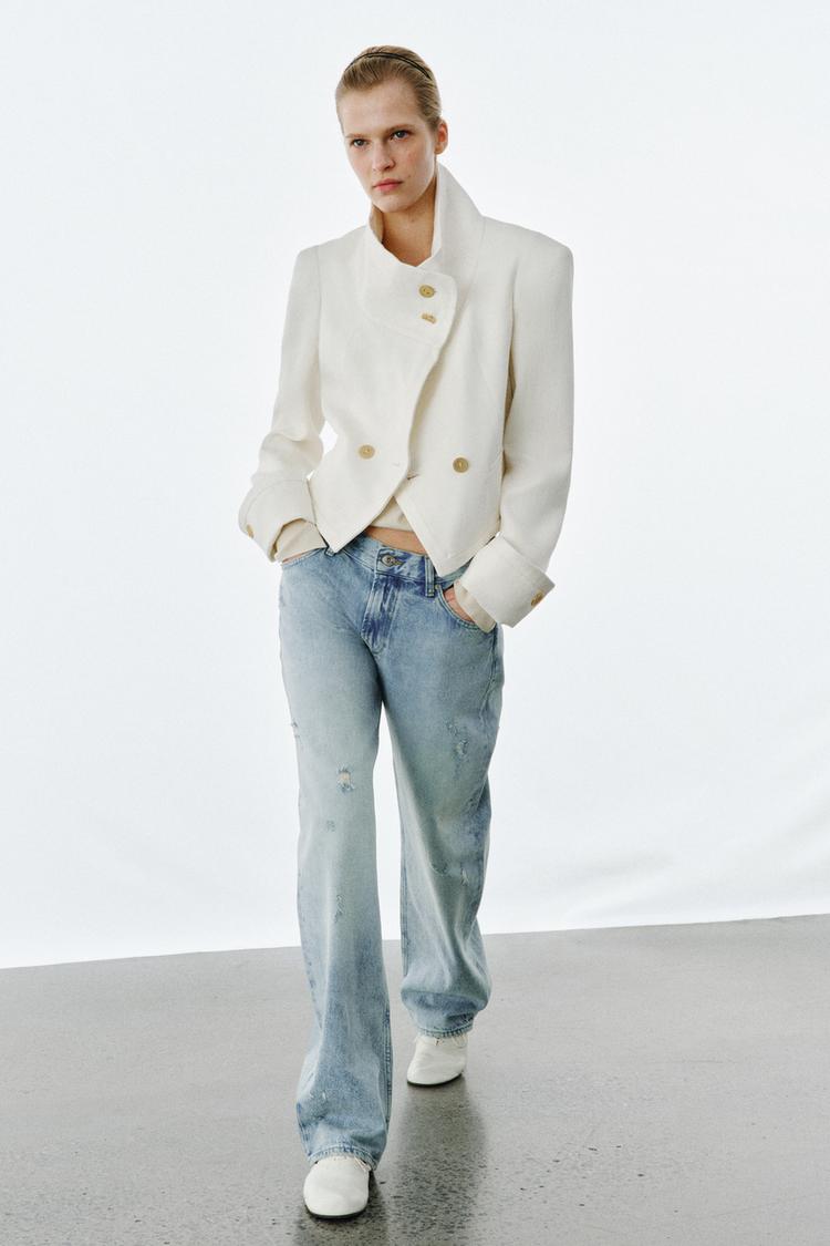 B�l� komplet s velk�mi knofl�ky a obno�en�mi modr�mi d��ny s bo�n�mi kapsami.