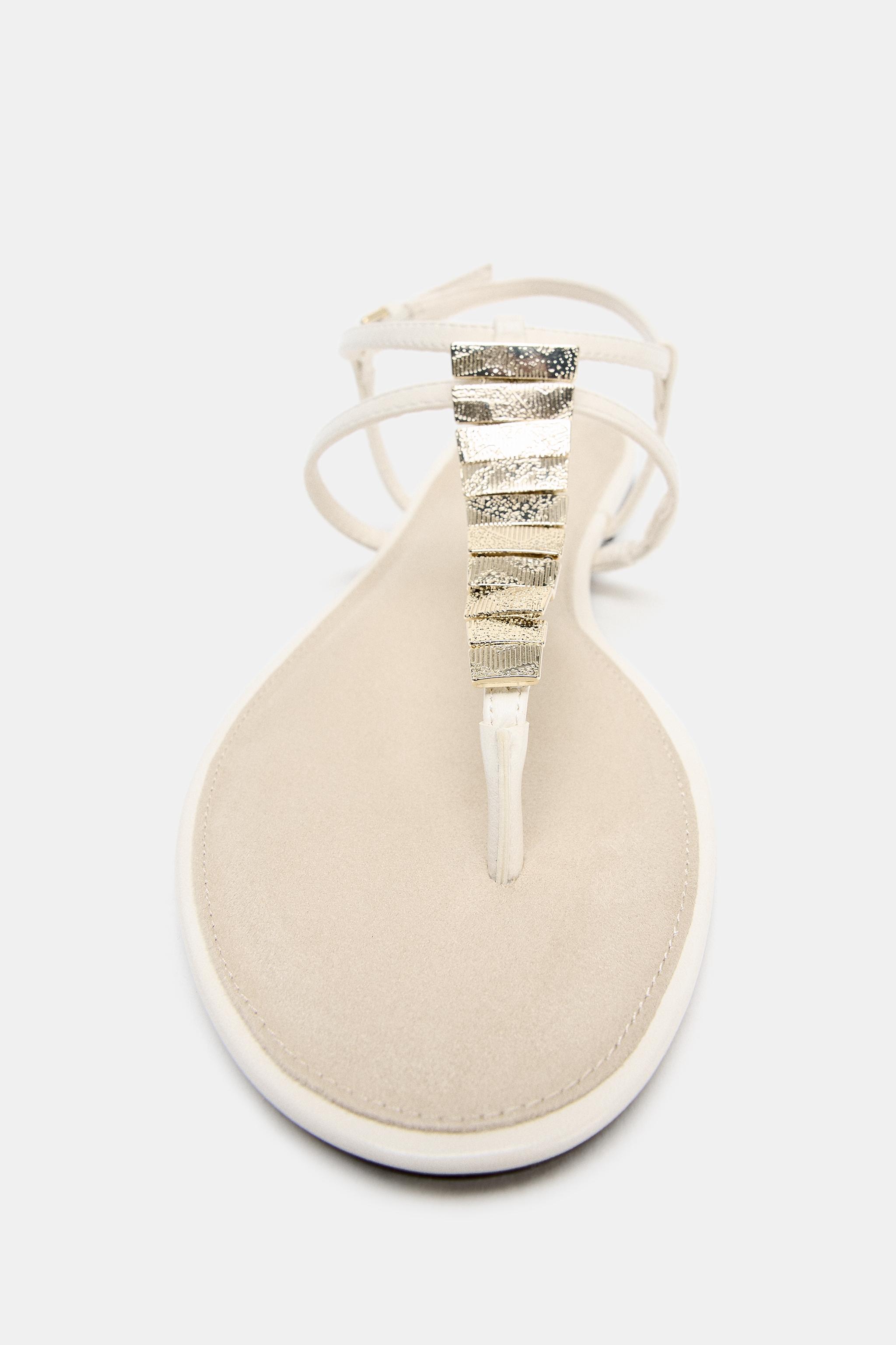 FLAT SANDALS WITH METALLIC APPLIQUES