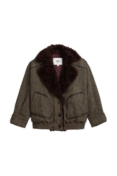 Front view of a brown jacket with a dark fur collar, front pockets, and button fastening.