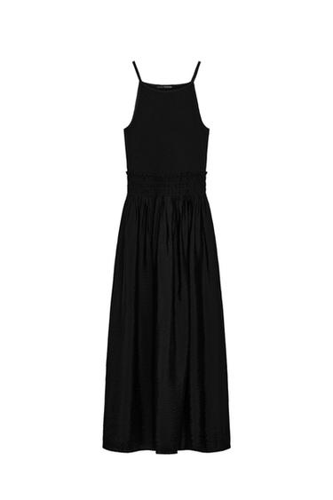 Front view of a black midi dress with spaghetti straps and a shirred elasticated waist.