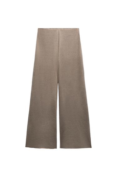 Front view of wide-leg beige trousers with no visible pockets.
