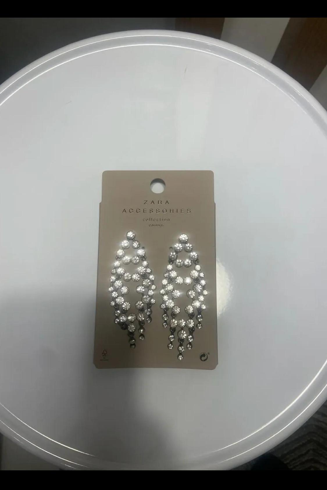 Drop earrings with rhinestones on a brown presentation card with 'ZARA ACCESSORIES' text.