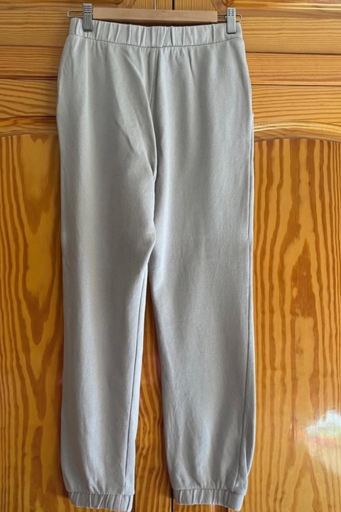Front view of grey trousers with an elasticated waist and elasticated cuffs.