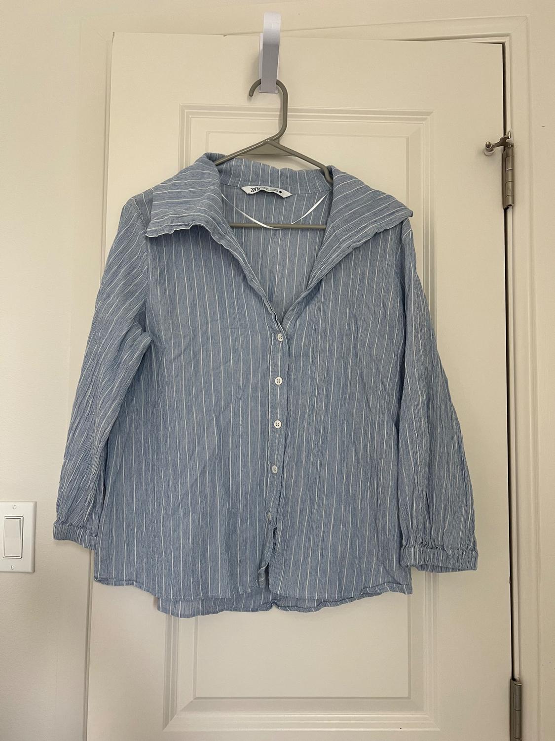 Front view of a blue shirt with white stripes and a wide collar.
