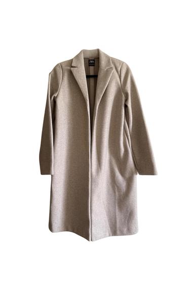 Front view of a long beige coat with lapels and long sleeves.