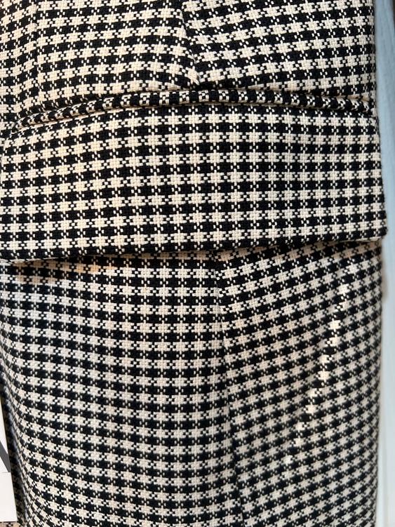 Close-up of a black and white checkered fabric, showing texture and stitching details.