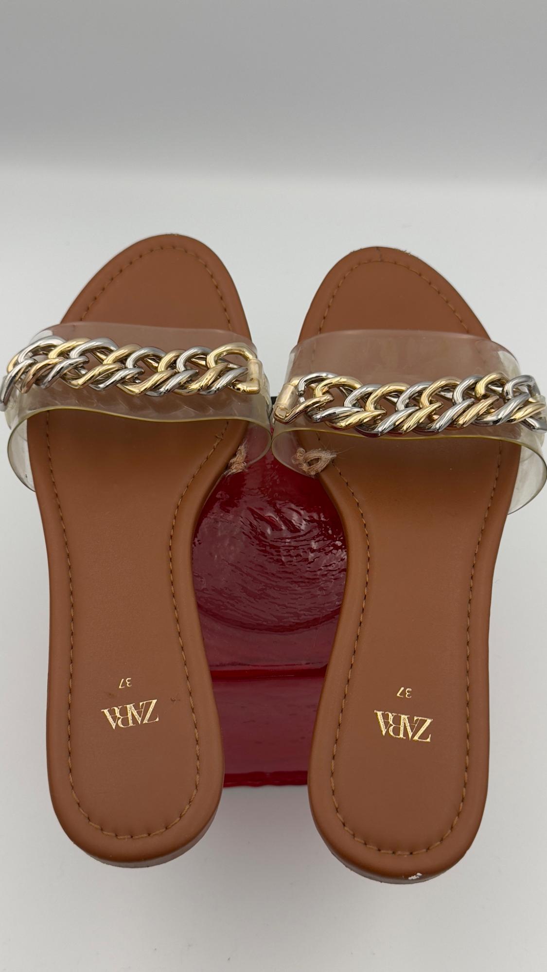 Brown sandals with gold and silver chain on a red base. Visible text: "ZARA 37".