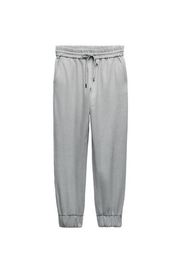 Light grey joggers with an elasticated waistband, adjustable drawstring and elasticated cuffs, on a white background.