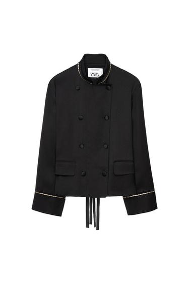 Black double-breasted jacket with an upright collar, gold chain detail on the collar and cuffs, flap pockets, straps and ZARA label.