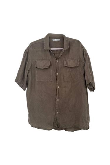 Short-sleeved button-up khaki shirt with two chest pockets, lightweight texture, on a white background.