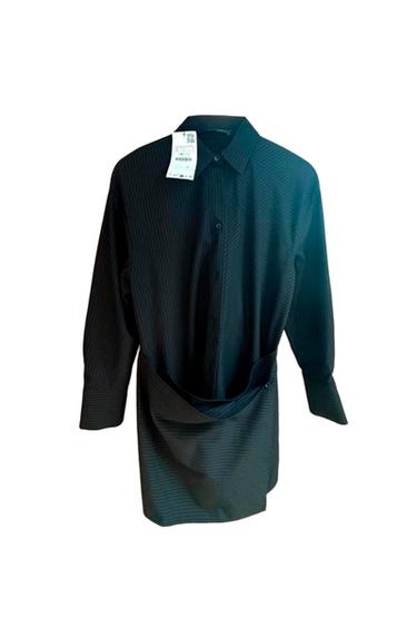 Black long-sleeved shirt with fine stripes, draped front detail and neck label, on a white background.