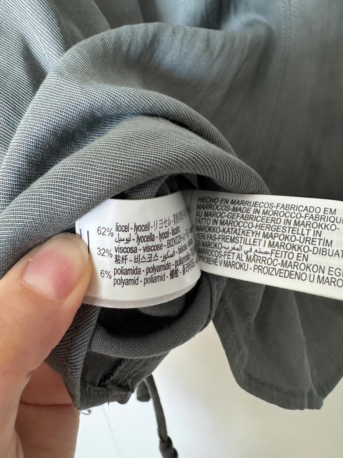 Grey clothing label with composition: 62% lyocell, 32% viscose, 6% polyamide. Text "Made in Morocco" in various languages.