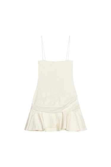Front view of a cream dress with spaghetti straps and a frilled skirt.