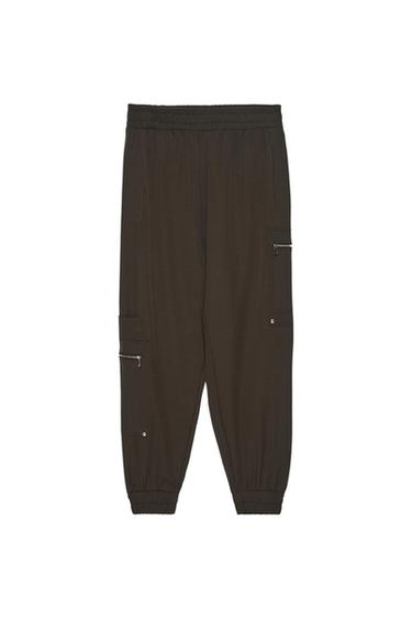 Dark brown cargo-style joggers on a white background. Featuring an elasticated waist and cuffs, and zip pockets.