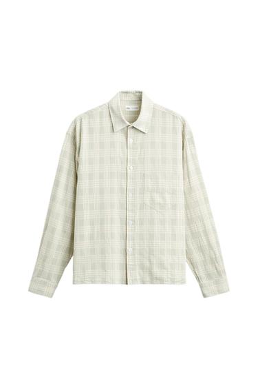 Long-sleeved shirt with a beige and white check print. It has a classic collar and front buttons.