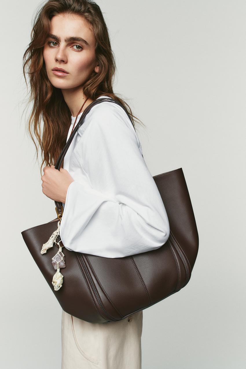 White blouse and brown tote bag set with decorative charm.