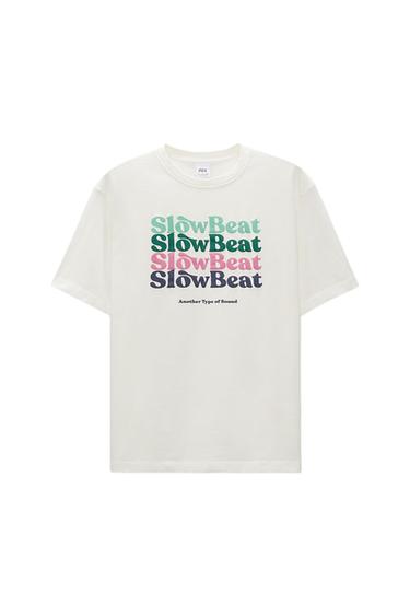 White T-shirt with "Slow Beat" text in green, blue, and pink, and "Another Type of Sound" in black. Simple and modern design.